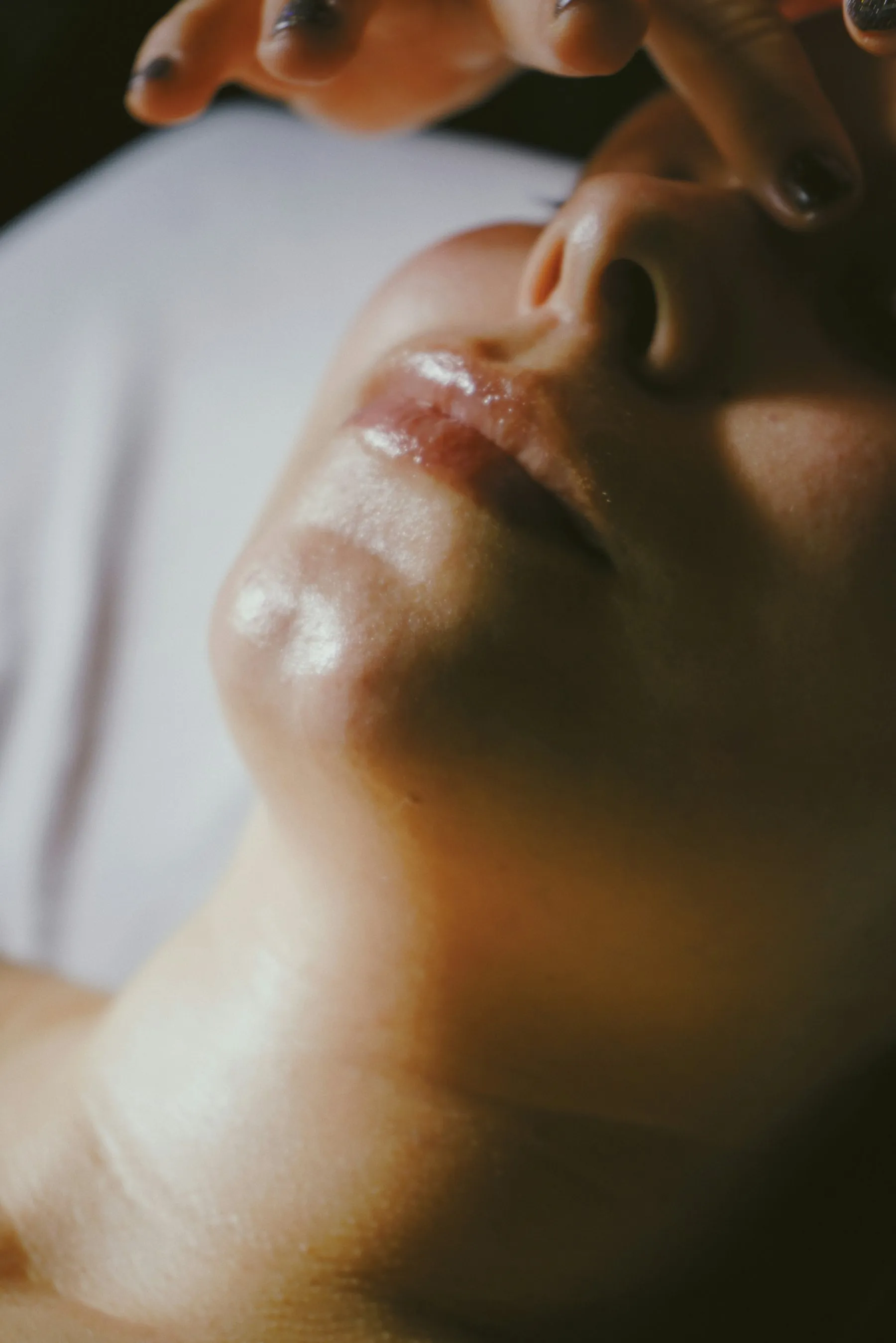 Warm, dewy close-up of a woman's face during a facial massage
